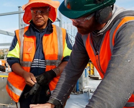 Two men look at plans at construction site