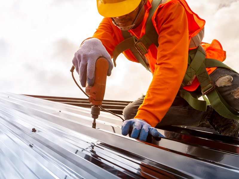 Man works on roof with drill